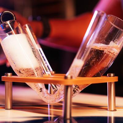 Champagne being poured into a uniquely-shaped hand-blown flute glass.