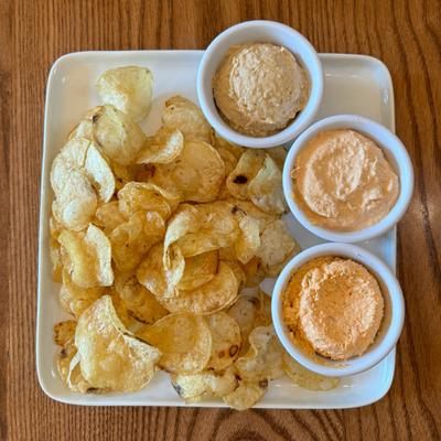 Assorted dips paired  with kettle chips.