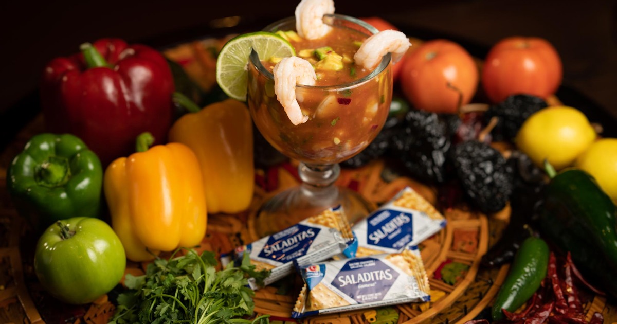 Shrimp cocktail glass and crackers served on the table decorated with fresh vegetables