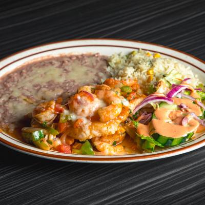 Shrimp plate with refried beans, rice, and salad with creamy dressing.