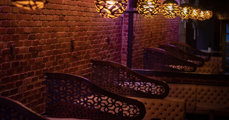 Interior featuring brick walls, soft lighting, and tufted seating