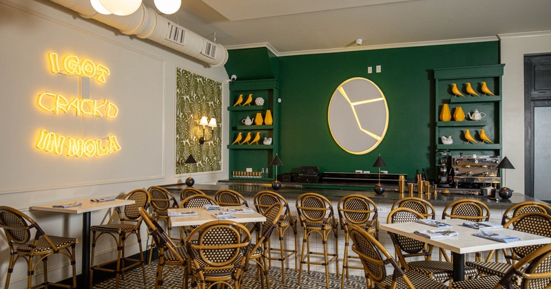 Inside area, tall tables, bar stools and neon sign on the wall