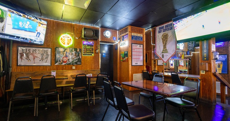 Interior, wooden decor, TVs showing sports, and various sports-themed posters and neon signs