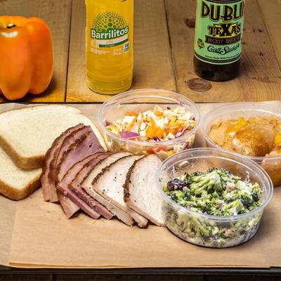 Sliced Ham and Turkey served with white bread, coleslaw, broccoli salad, and peach cobbler.