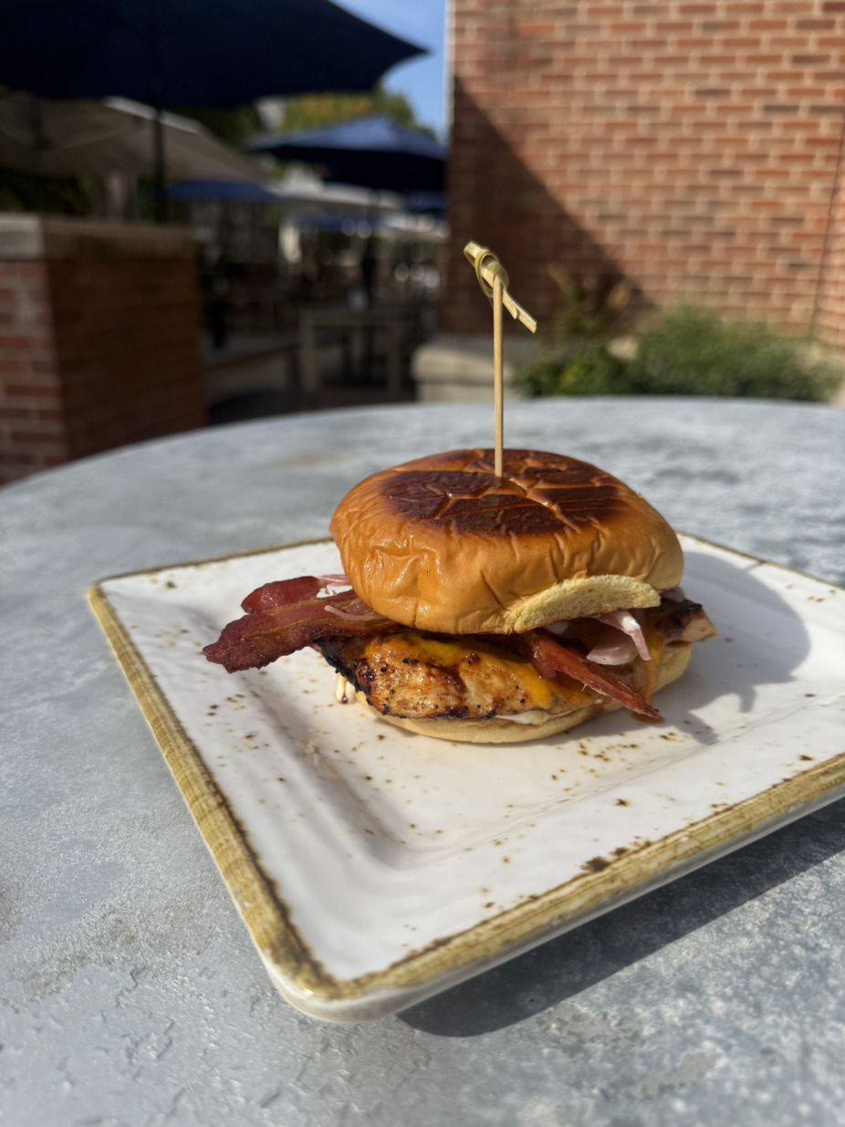 Maple Bourbon Chicken and Bacon:  Wood-grilled chicken, applewood smoked bacon, maple-bourbon glaze, sharp cheddar, pickled red onion, and an apple cider aioli on grilled brioche.