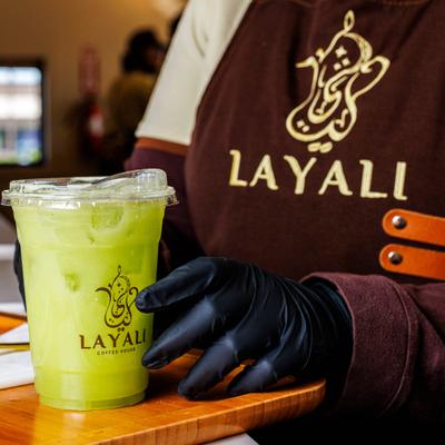 A server holds a Matcha drink.