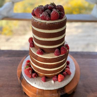 Two tier brown and white striped cake, garnished with red berries