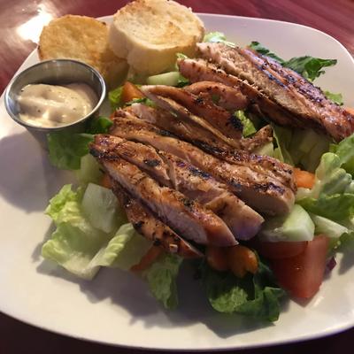 Grilled Chicken Salad, with carrots, tomato, cucumber, onion, and garlic bread.