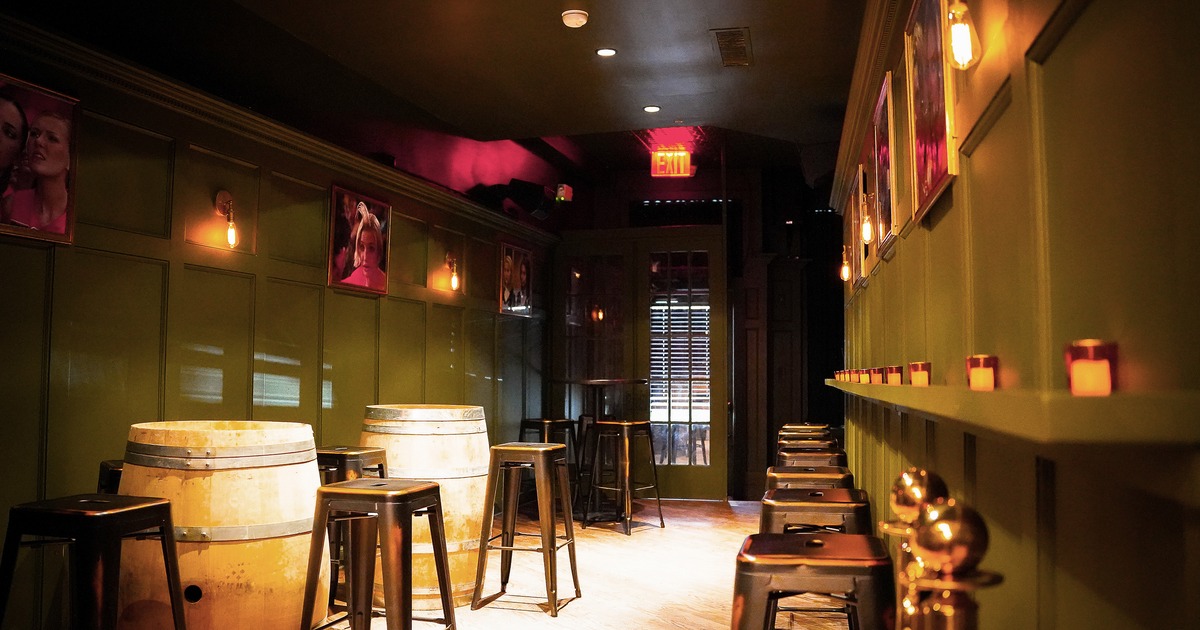 Back room seating area with wooden barrel tables and high stools
