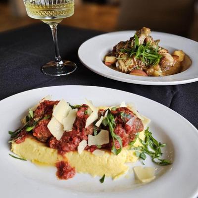 Meatballs on a bed of polenta, accompanied with a meat based entree and sparkling wine.