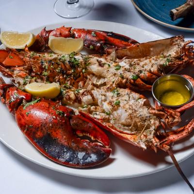 Grilled lobster with lemon wedges and melted butter.