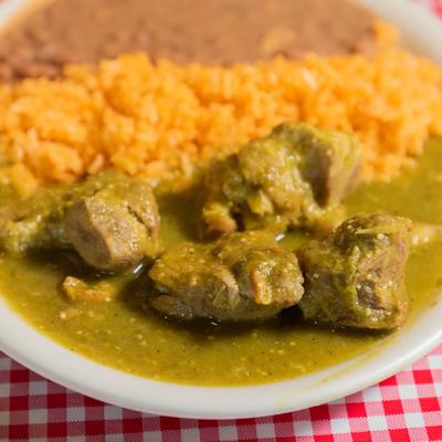 Pork chunks smothered in green chile, served with rice and beans.