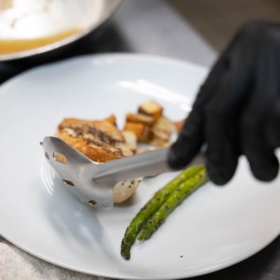 Close up, serving food on plate.
