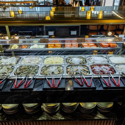 Buffet setup featuring various iced platters of raw seafood.