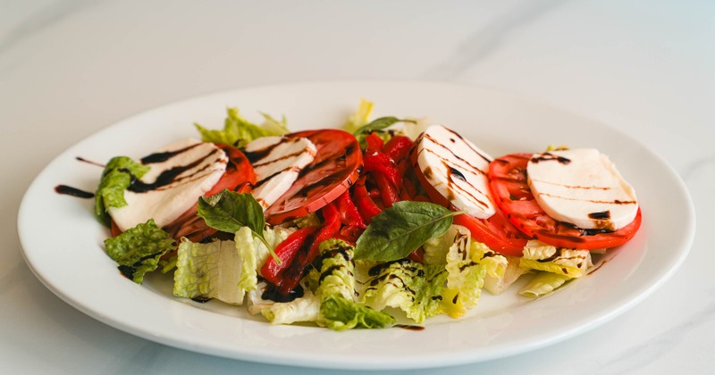 Caprese salad with lettuce, toamato, basil, mozzarella and balsamic glaze