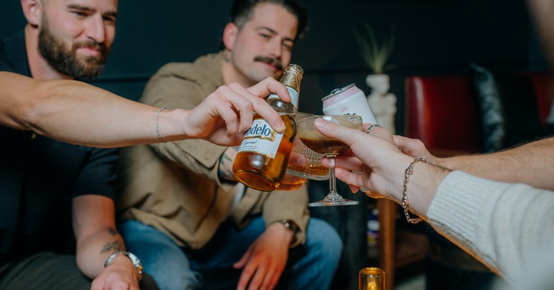Group of people toasting with glasses and bottles
