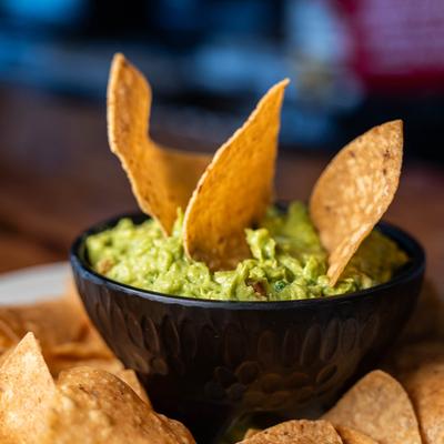 Guacamole dip with tortilla chips, close up.
