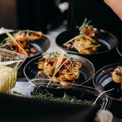 Black plates of seafood dishes with hebs.