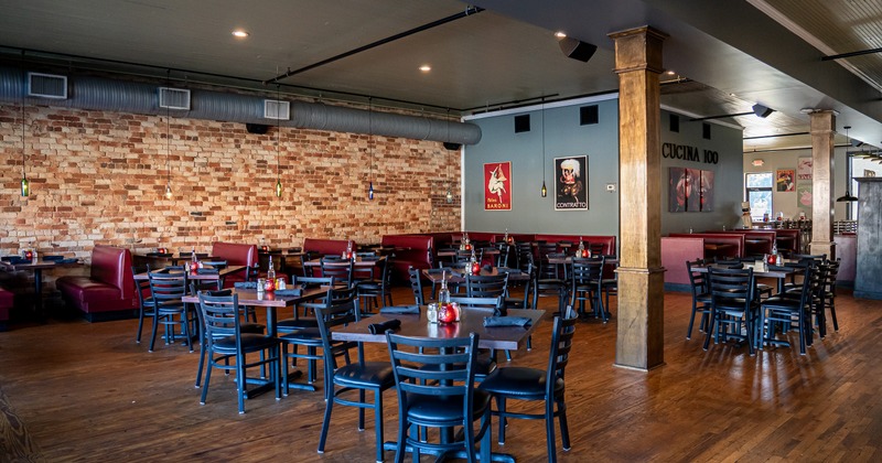 Spacious dining area with booths along the wall and set tables and chairs ready for guests
