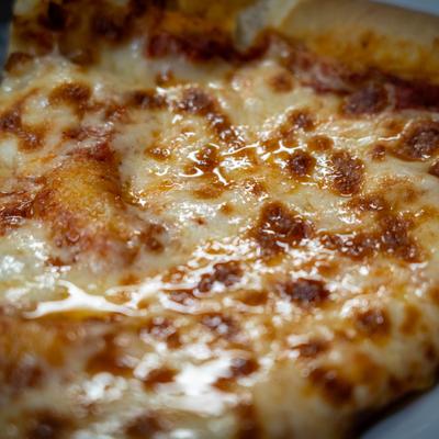 Extreme close up of a slice of cheese pizza.