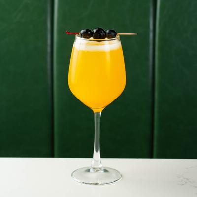 Mimosa with cherry and blueberry garnish.