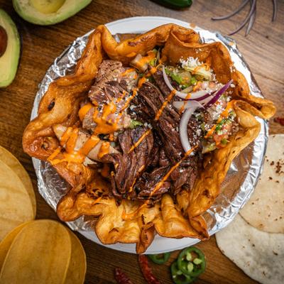 Asada salad featuring grilled steak and fresh vegetables served in a crispy tortilla shell.