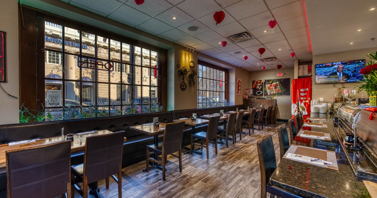 Cozy restaurant with wooden floors, brown leather chairs, and tables set for dining