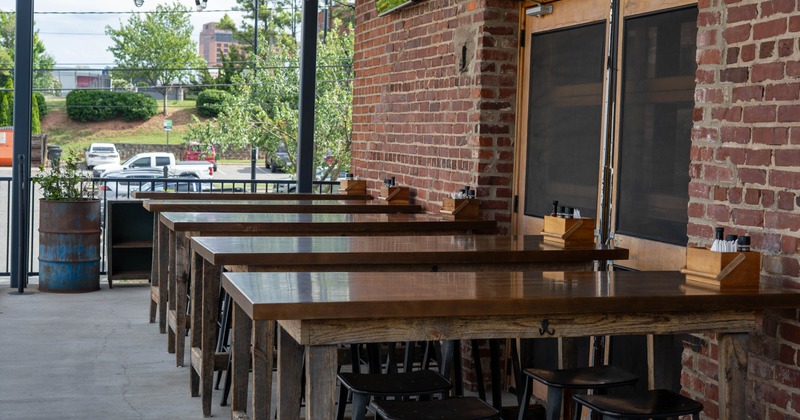Exterior, patio, seating area, wooden tables with chairs, exposed brick walls