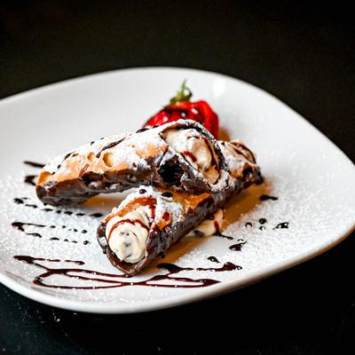 Cannoli, dipped in chocolate syrup.