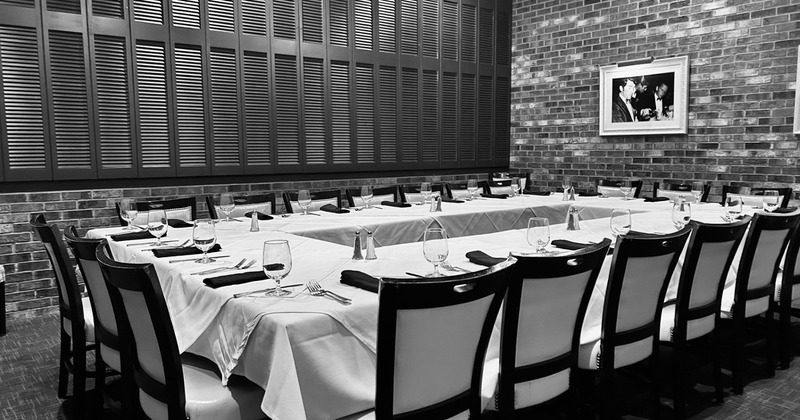 A long table set for dining in a brick-walled room