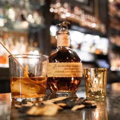 glass of whiskey next to Blantons bottle.