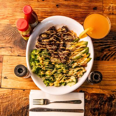 Steak Yum Yum Bowl served with an orange drink.