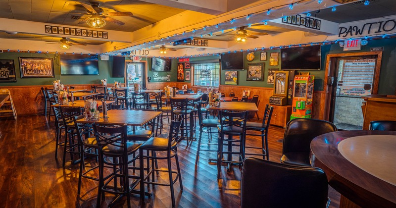 Interior, high seating area, high wooden top tables with stools, entrance on the right