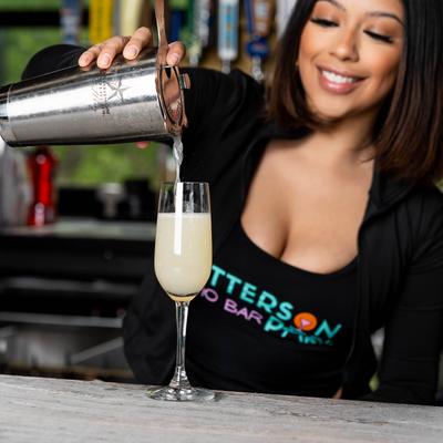 Bartender pouring a mixed drink using a shaker