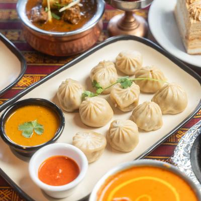A vibrant spread of Indian cuisine features steamed dumplings surrounded by various dishes.