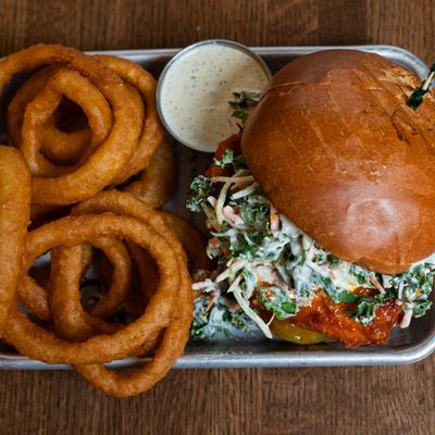 Fried chicken sandwich, with slaw, pickles, jalapeno ranch, and a side of onion rings.