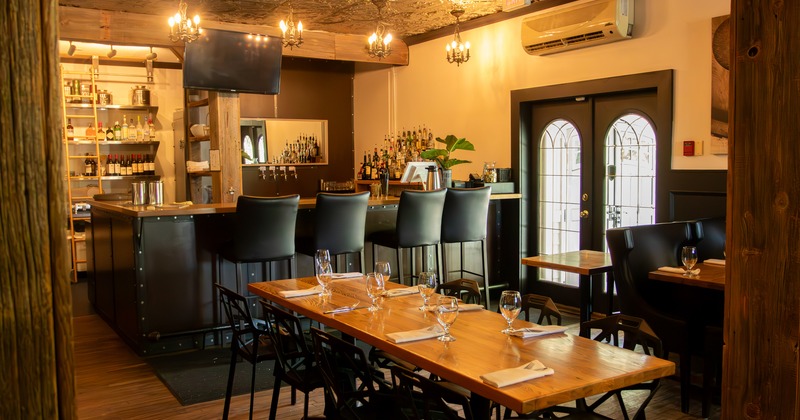 Diner area, diner table, chairs, bar and bar stools behind
