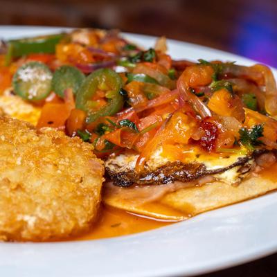 Huevos rancheros with hash browns, close up.