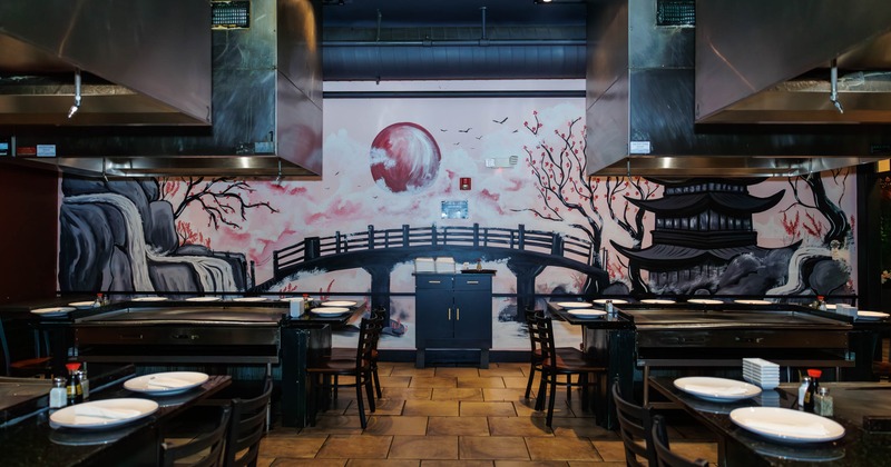 Japanese-themed interior with mural of a bridge, pagoda, and cherry blossoms
