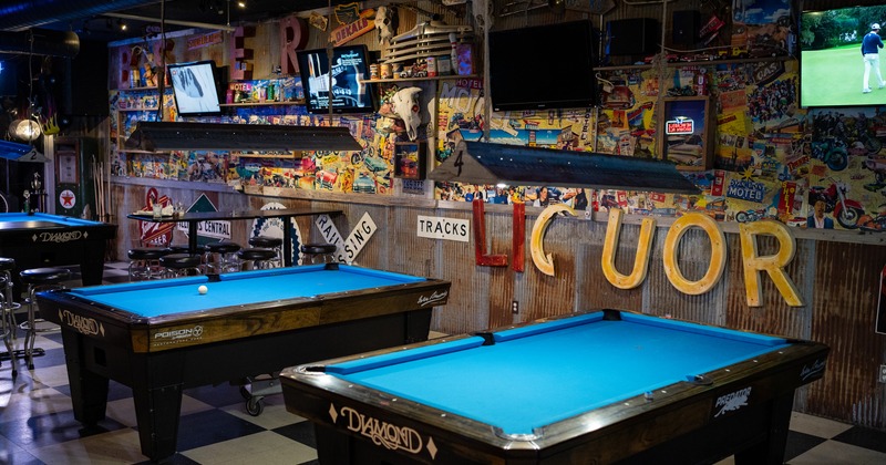 Interior, pool tables, decorated wall with TVs