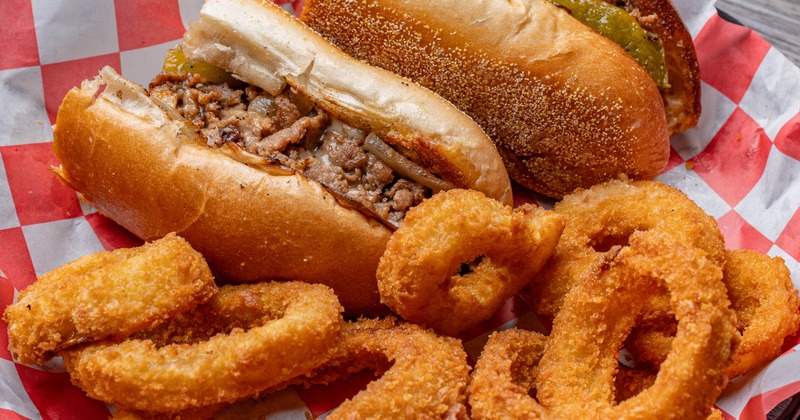 Philly Cheesesteak sandwich served with onion rings