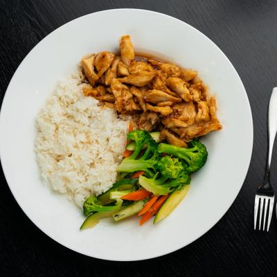 Asian-style chicken with rice and vegetables including broccoli and carrots.