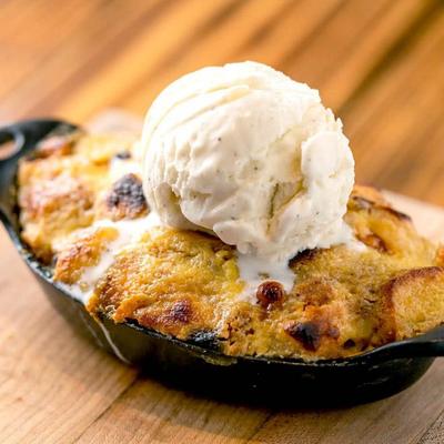 Bread pudding topped with ice cream.