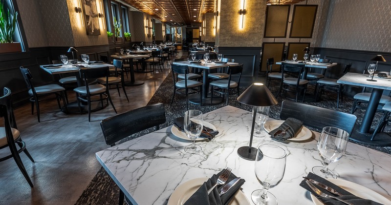 Interior, tables and chairs with table ware and glasses