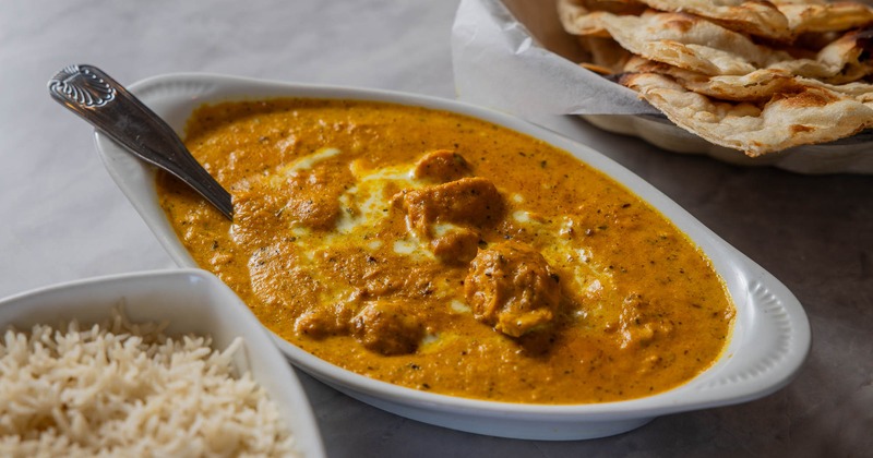 Chicken korma with naan bread and rice on the side