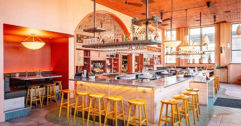 Interior, bar area, marble top bar with wooden stools, seating booth on the left