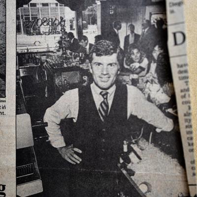 Paul Dobson, the owner, posing behind the crowded bar