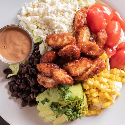 Chopped salad, with lettuce, black beans, corn, tomato, feta, avocado, BBQ chicken and dressing.