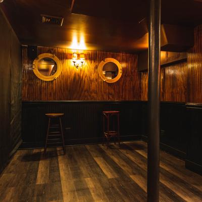 Interior, tables and bar stools by the wall.