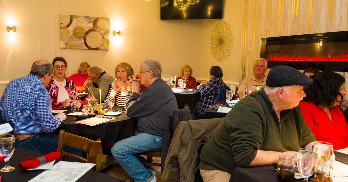 People dining at tables in a busy warmly lit restaurant